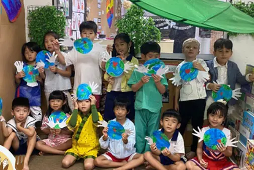 Children holding earth craft projects during classroom learning