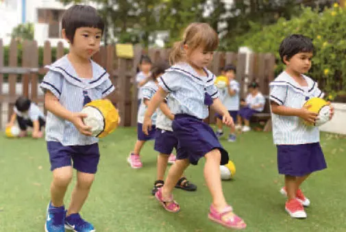 Preschool children playing soccer outdoors at Pegasus International Preschool