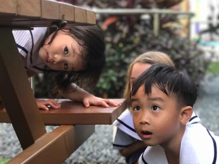孩子们在户外桌子下探索与玩耍