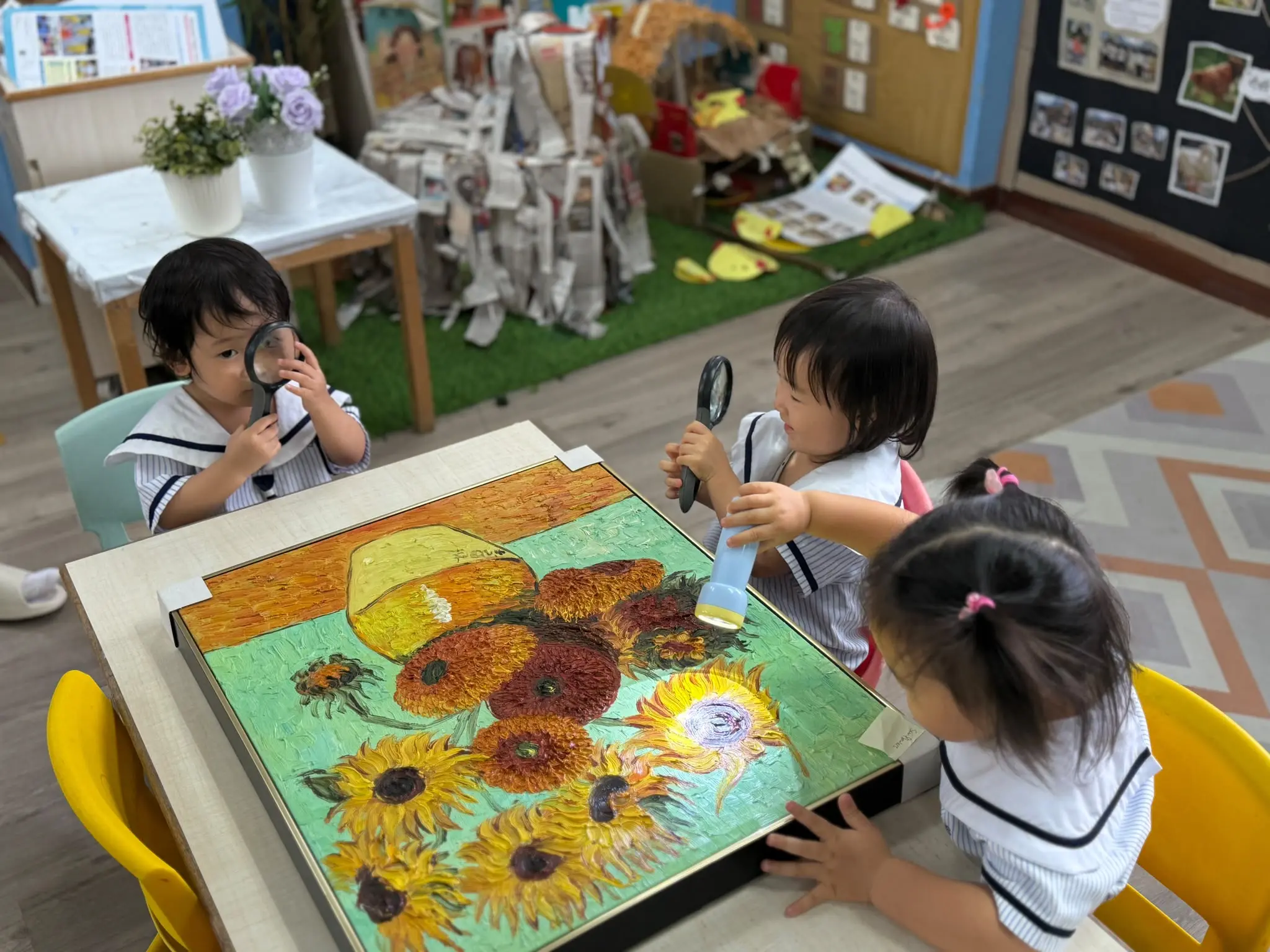 Nursery children exploring paint with magnifying glasses at Pegasus International Preschool in Novena, Singapore
