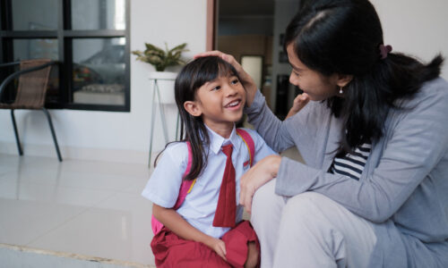 happy primary student at back home after school and talk to her mother