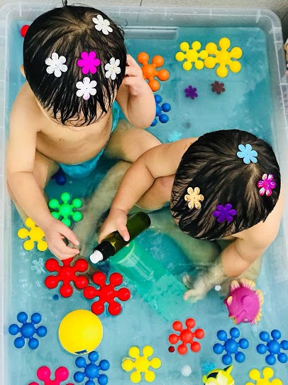 Two children playing in the water at Pegasus International Preschool